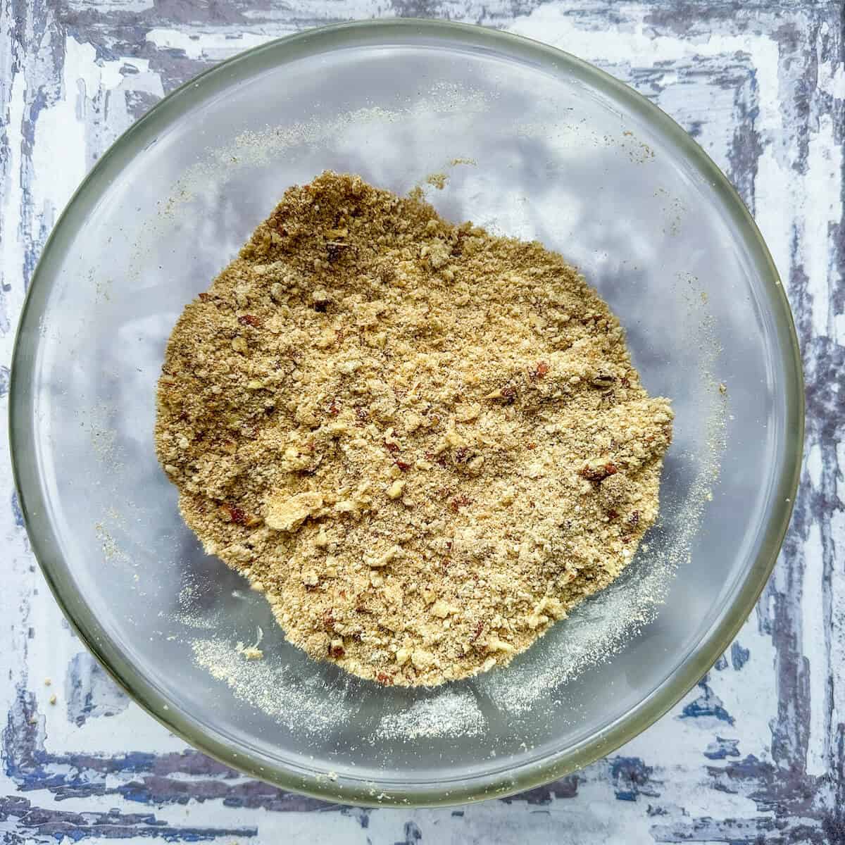 Crumble topping made from flour, butter, pecans, salt and baking powder in a mixing bowl. 
