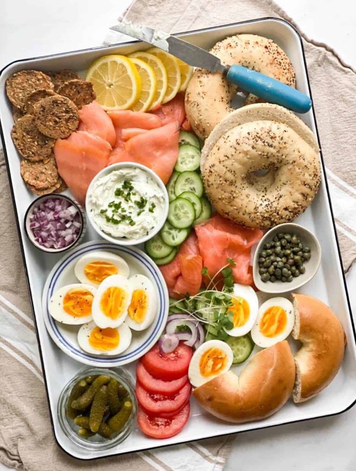 A bagel board with bagels, salmon and cream cheese. 