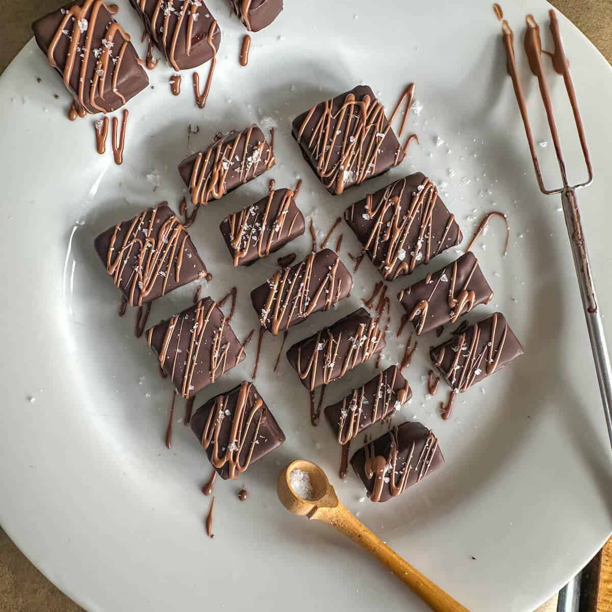 Decorated chocolate and sea salt truffles on a plate.