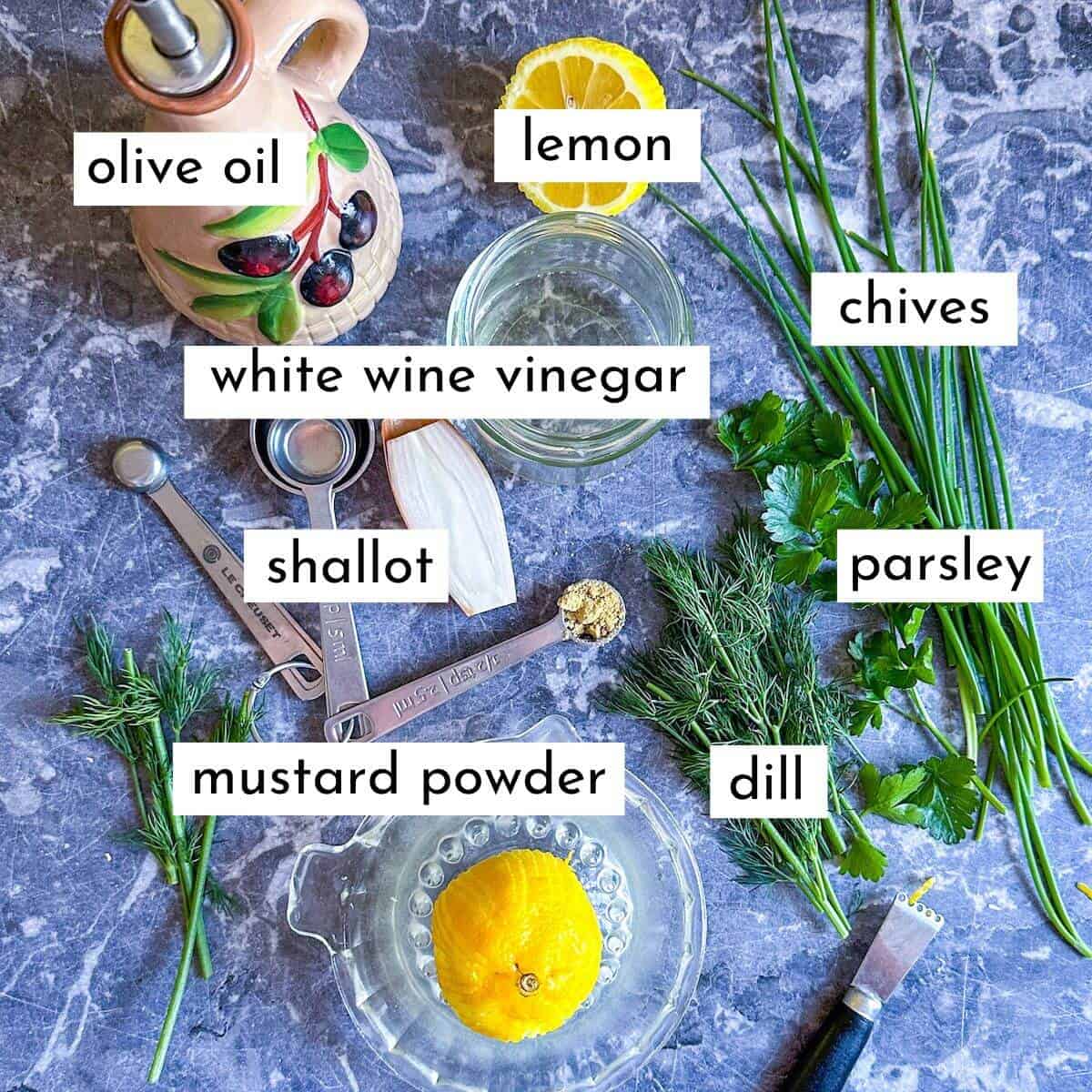 The ingredients for a lemon herb vinaigrette laid out on a worktop. 