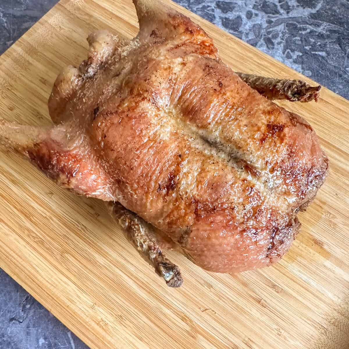 A roasted duck on a carving board. 