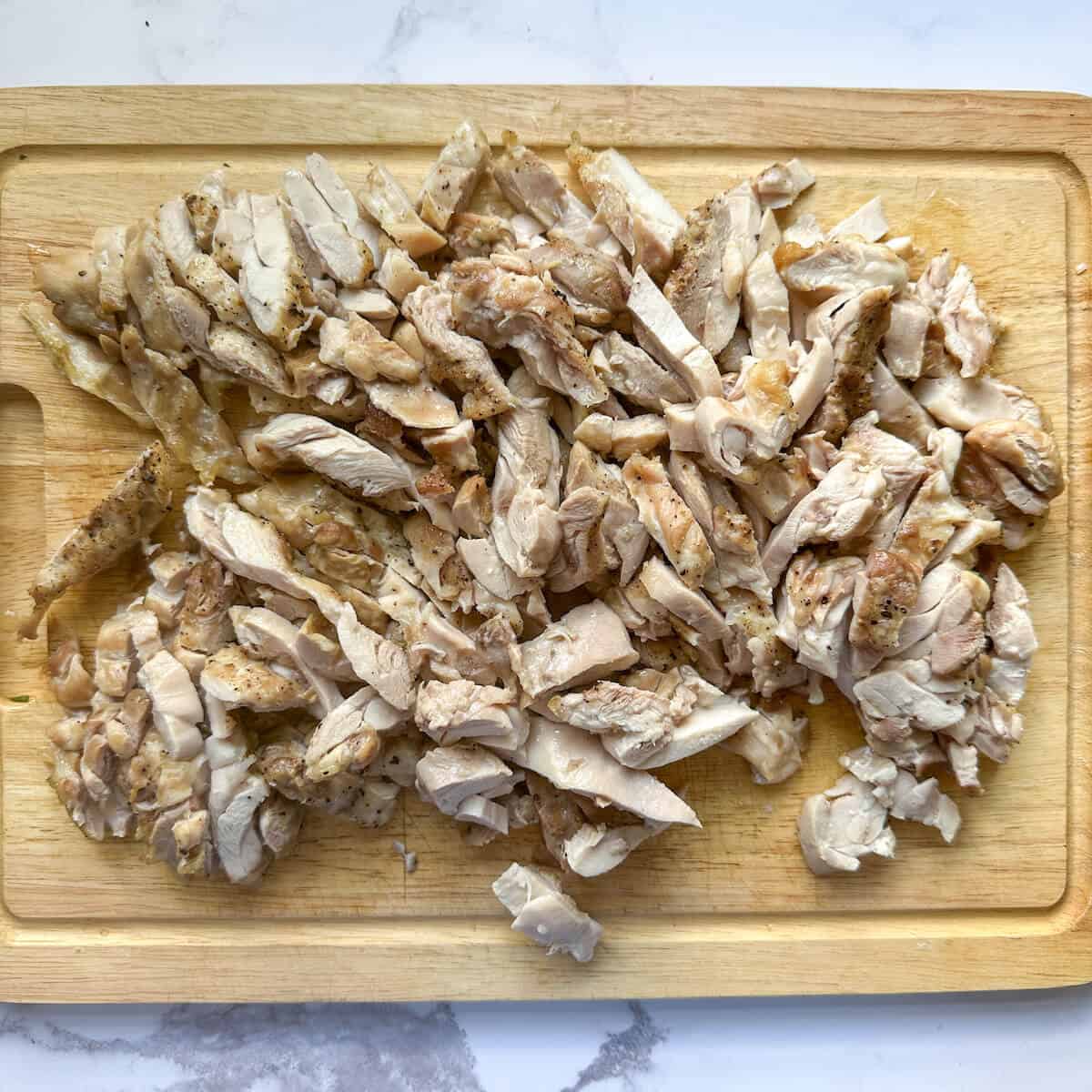Cooked, chopped chicken on a cutting board. 