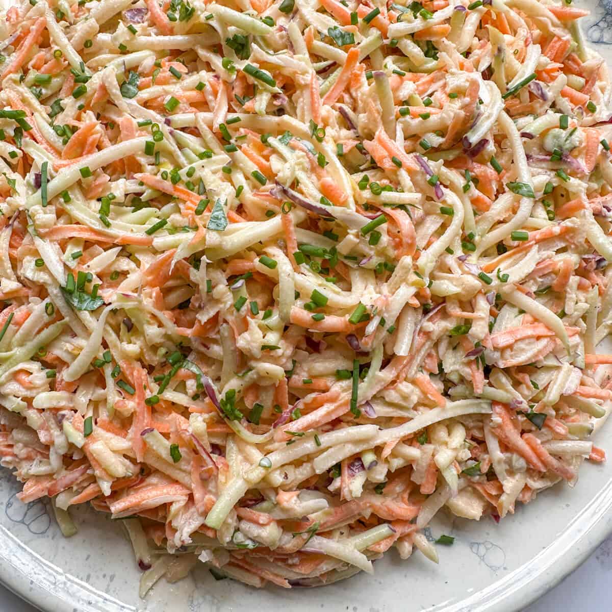 A close up of grated kohlrabi coleslaw on a serving plate. 