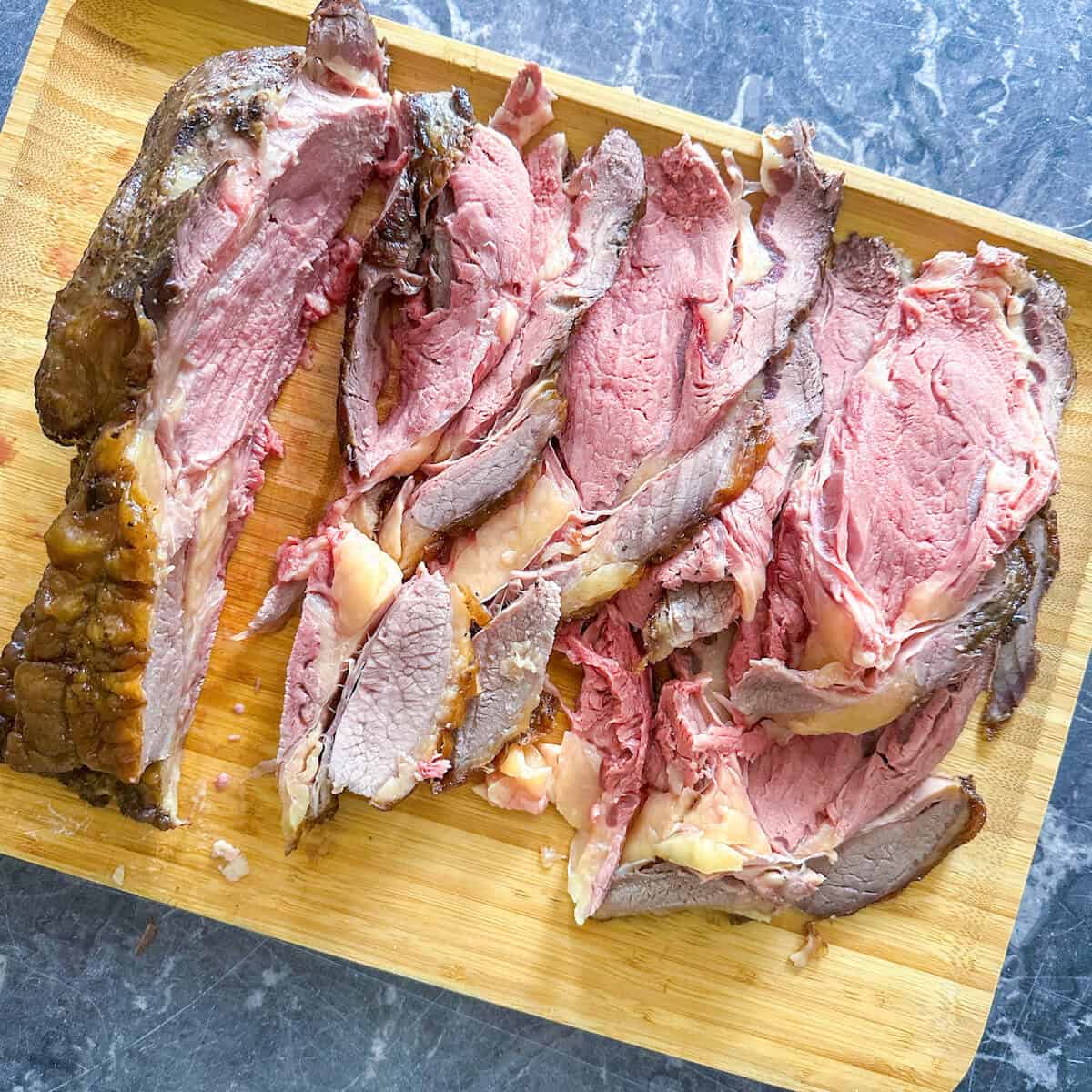 Carved standing rib roast on a wooden carving board.
