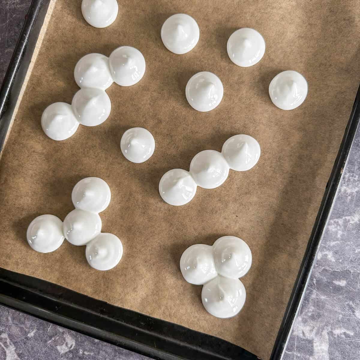 Piped meringue on a lined baking tray. 