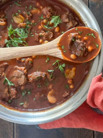 Rich and tender beef tagine in a stainless steel pan on a table.