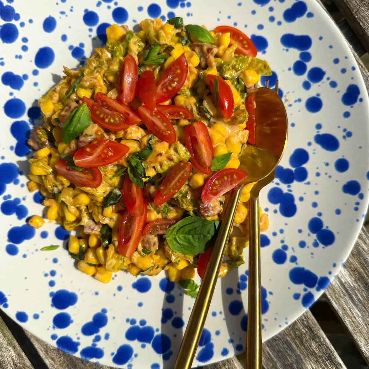 Summer Corn Fricassee on a plate on a garden table.