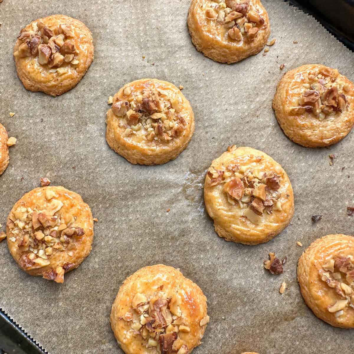 Baked walnut and parmesan sables on an oven tray. 