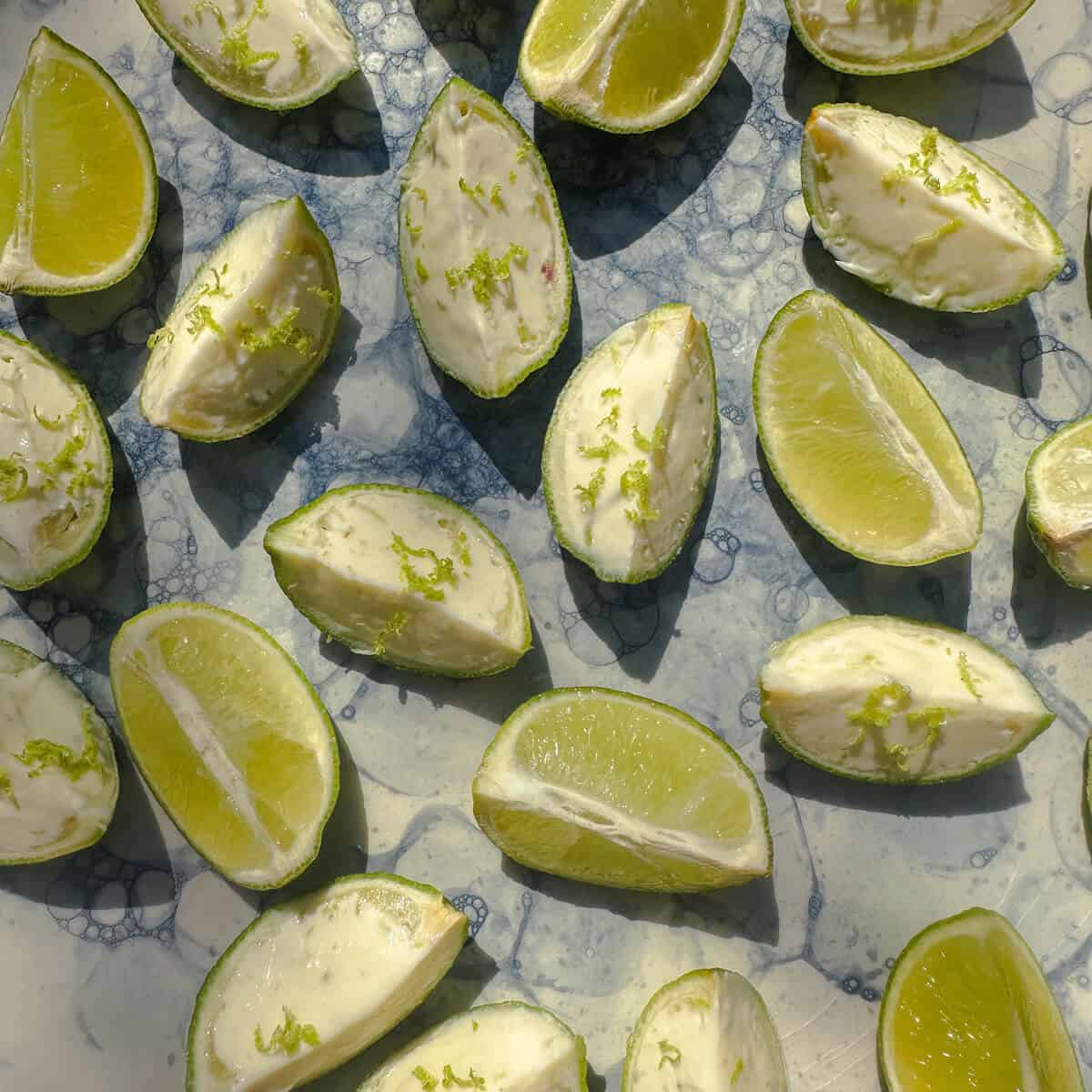 A platter of fresh lime wedges mixed with lime ice cream wedges. 