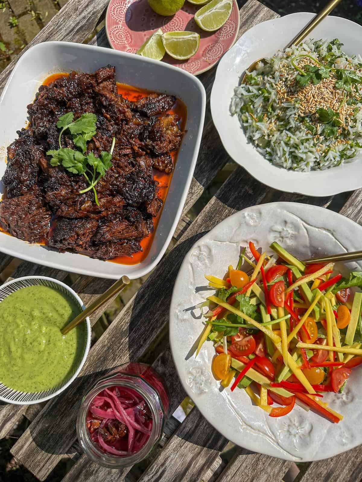 Spicy mango avocado salad on a table with other dishes. 