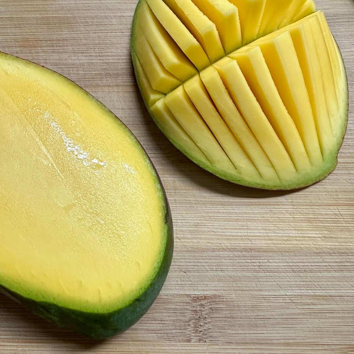 A mango being sliced up to avoid the stone. 