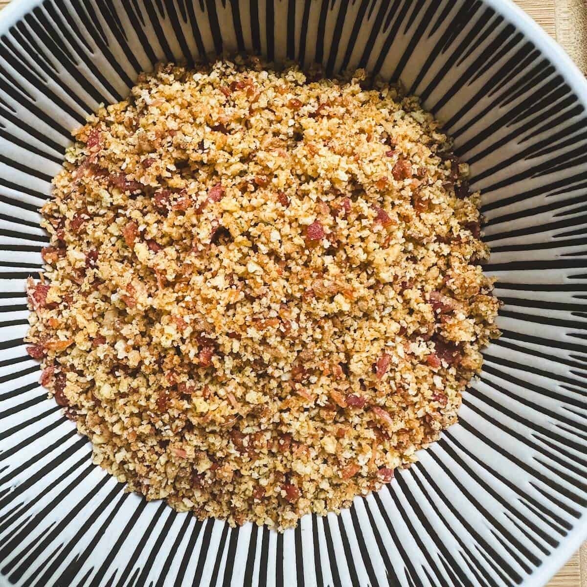 A bowl of panko breadcrumbs mixed with crispy bacon.