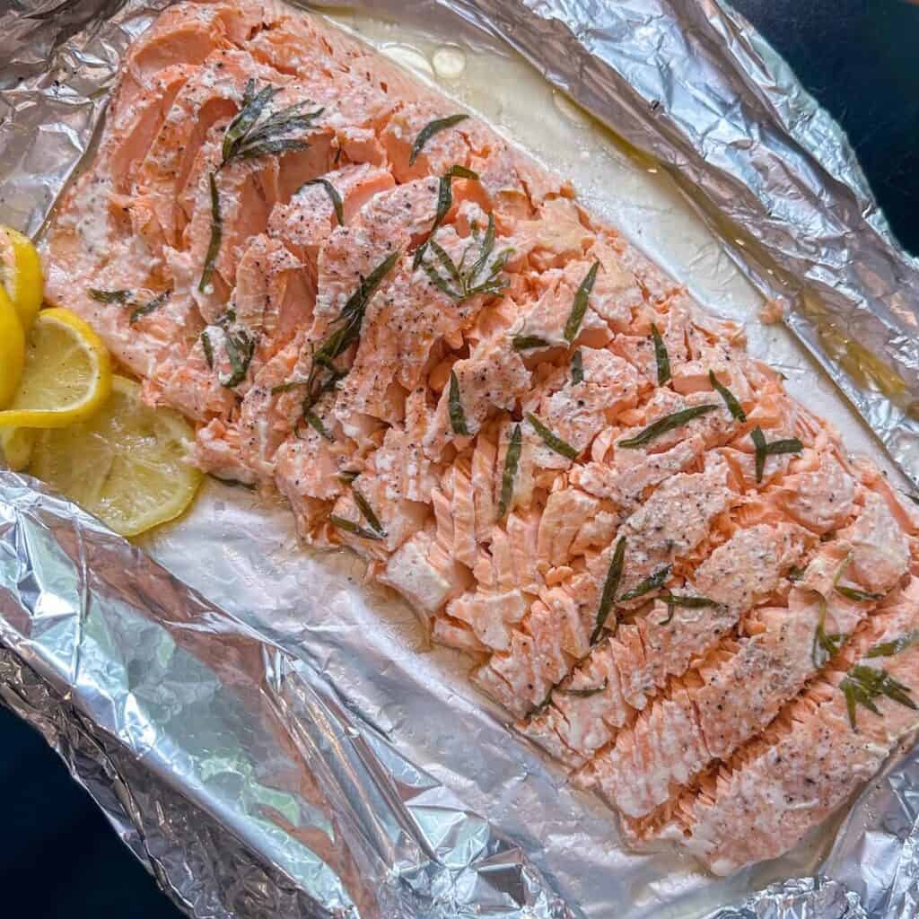 A whole side of salmon en papillote sliced up into individual portions.
