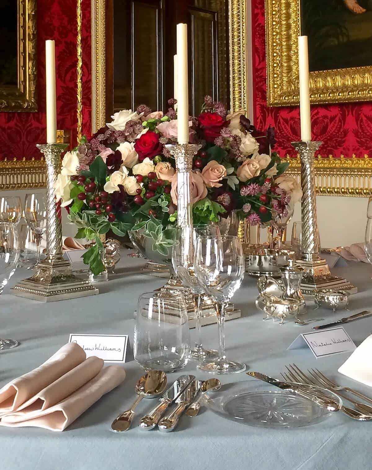 A formal table set for an event with multiple fine stem glasses, cutlery, napkins and placecards.