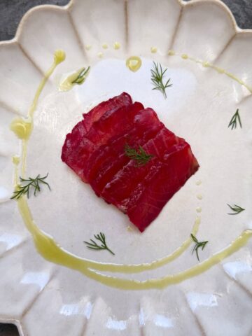 Beetroot Gravadlax on a plate with dill oil.