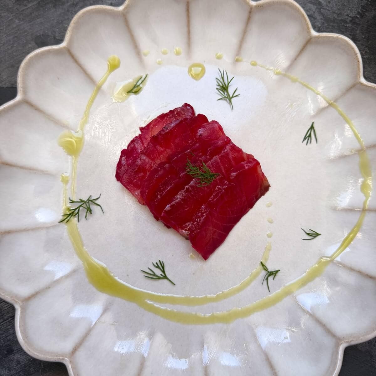 Beetroot Gravadlax on a plate with dill oil.