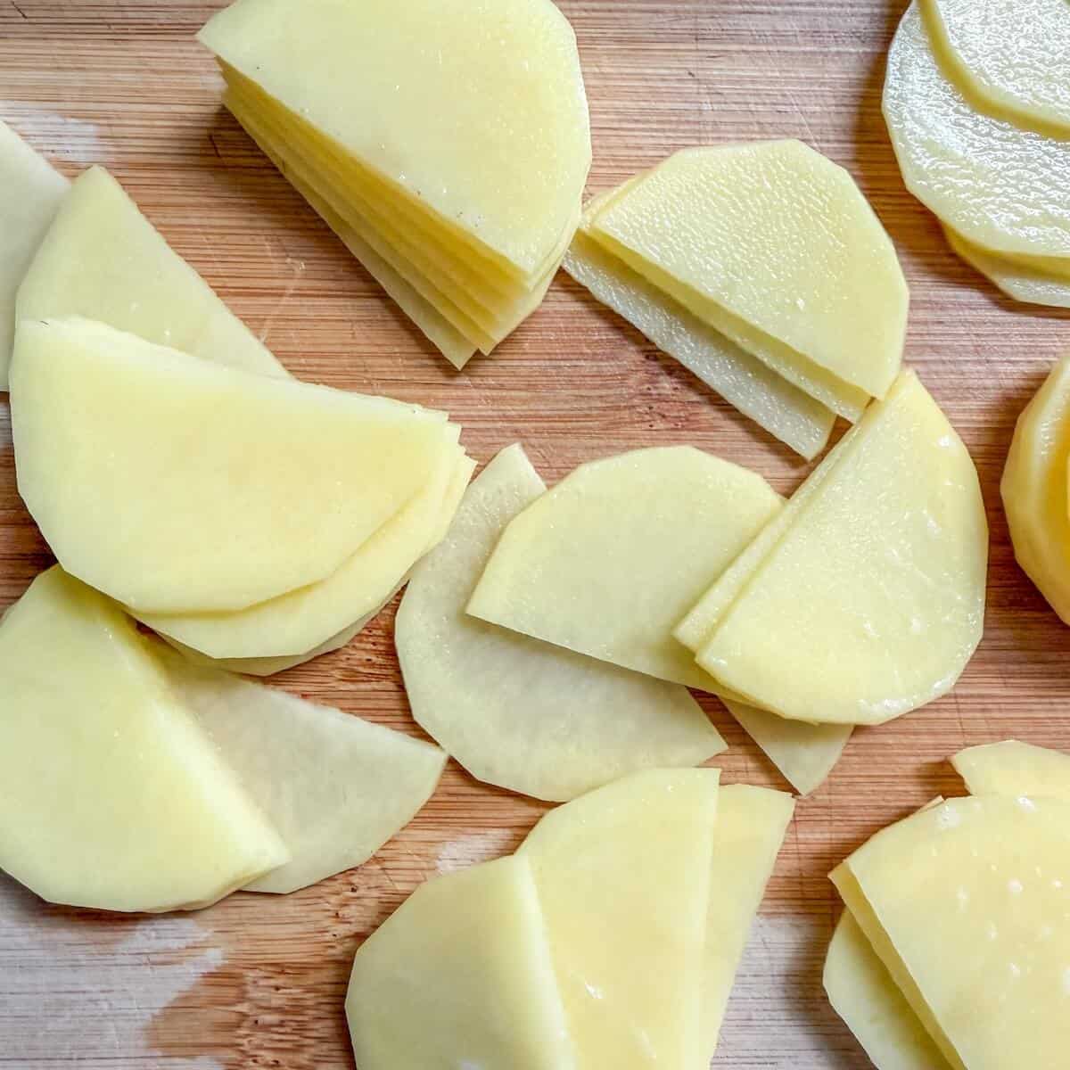 Slices of potato on a chopping board.