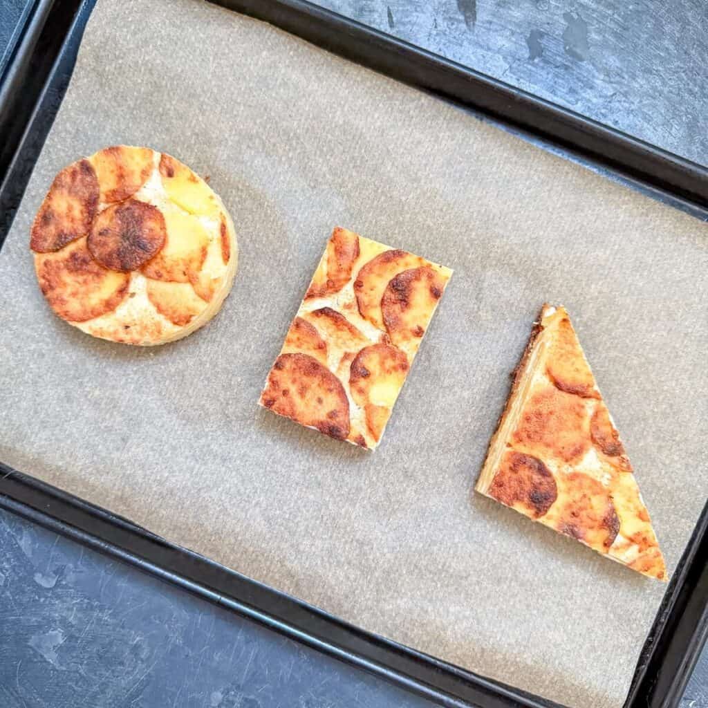 Dauphinoise Potatoes on a baking tray, cut into shapes.