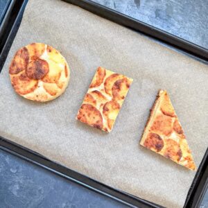 Dauphinoise Potatoes on a baking tray, cut into shapes.