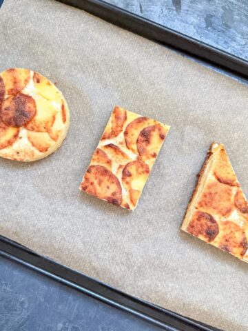 Dauphinoise Potatoes on a baking tray, cut into shapes.