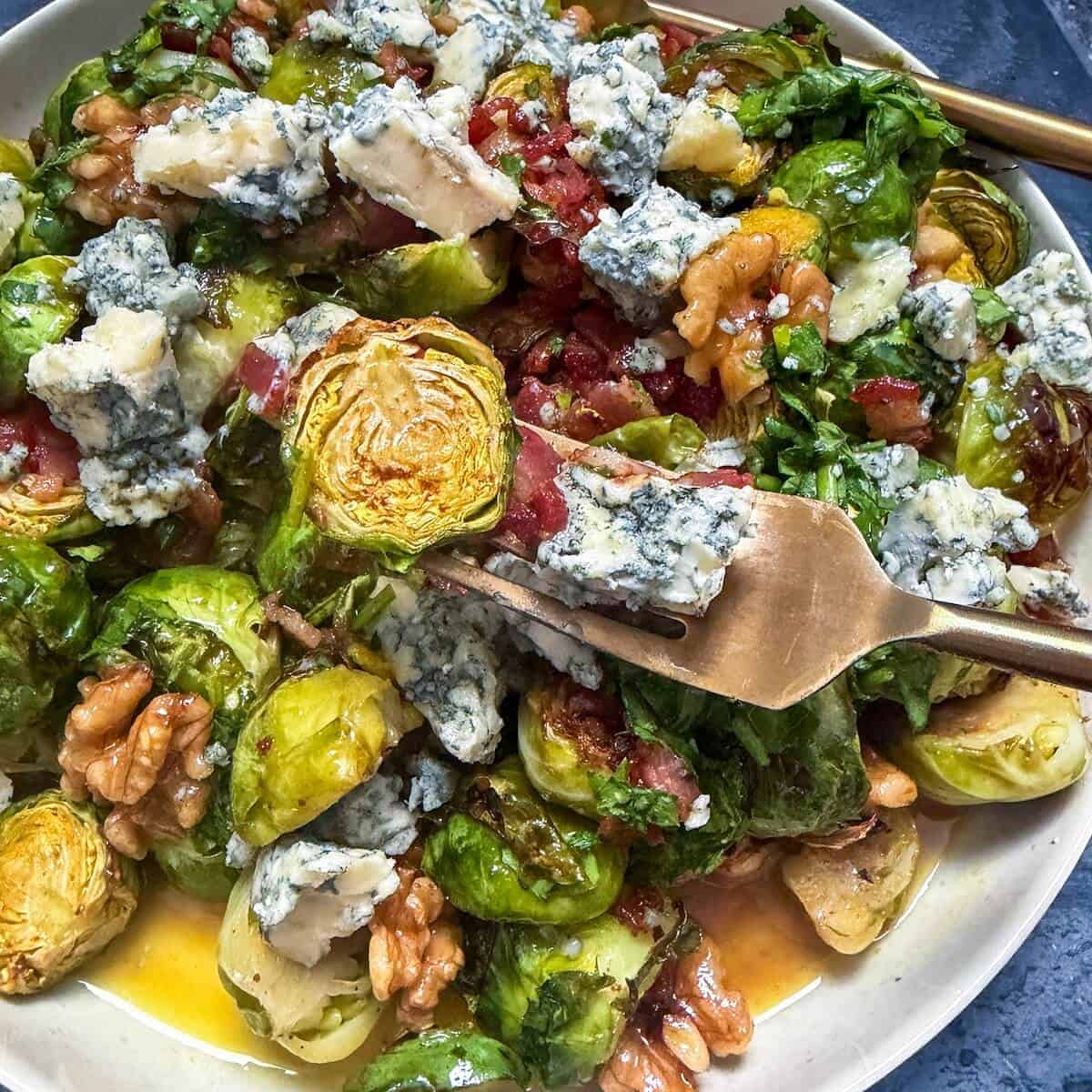 A plate of brussels sprout salad with blue cheese and pancetta