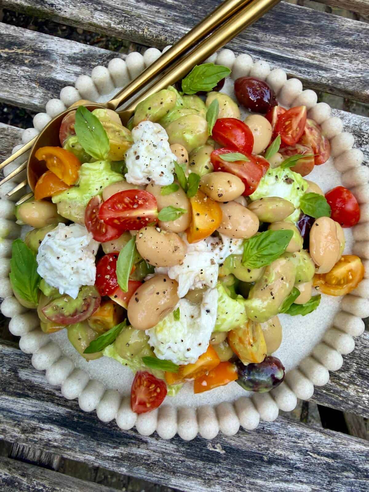 A serving of butterbean caprese salad with creamy basil avocado dressing.